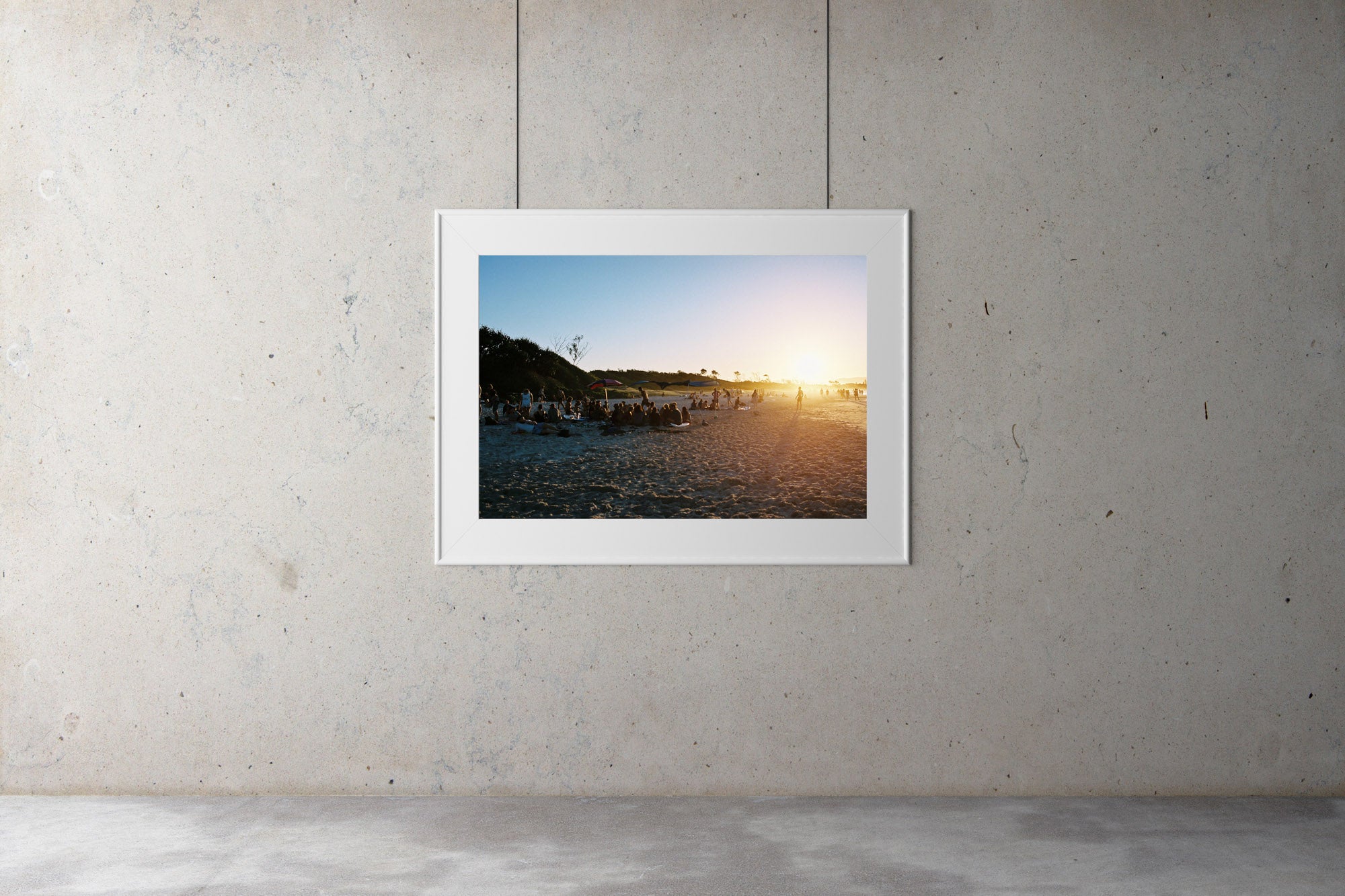 People sit in groups on the beach at sunset in Byron bay. The sun is low & the beach & blue water looks warm.  People are walking in the distance, blue calm water, blue sky.  Artwork Prints, wallart,  Photographic prints,  Framed artwork,  Australian  Photography, wall art, beach prints, coastal prints, ocean prints,  Film photography, Vintage photo, style  Interior design, Pictures Abstract film photography, photography art, Australia, sun, beach,