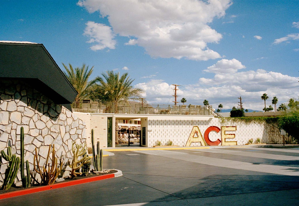 A photograph of the outside of the Ace Hotel in Palm Springs California. There is a large mid century sign that says ACE Blue skies & clouds with palm trees in the background. USA, Artwork, Prints, wall art, California, Photographic prints, Palm Springs, 