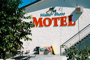 A photograph of a 1960’s motel with a big red sign that says motel