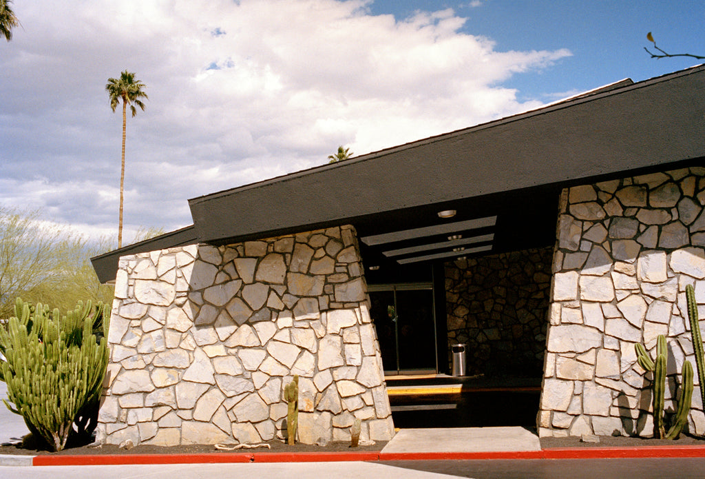 A photography of the Ace Hotel stone wall in Palm Springs. A rmid century stone building.